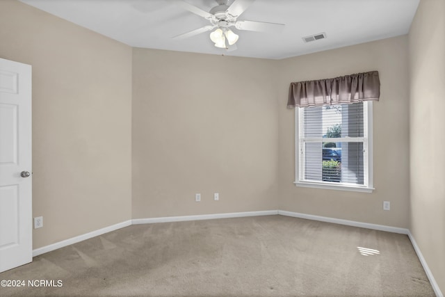 empty room with visible vents, carpet, ceiling fan, and baseboards