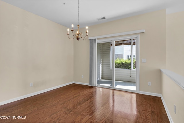 unfurnished room with baseboards, visible vents, dark wood-type flooring, and a chandelier