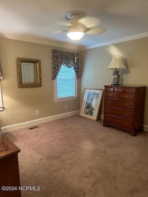 carpeted bedroom with ornamental molding and ceiling fan