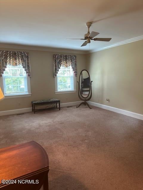 interior space featuring carpet flooring, ornamental molding, and ceiling fan