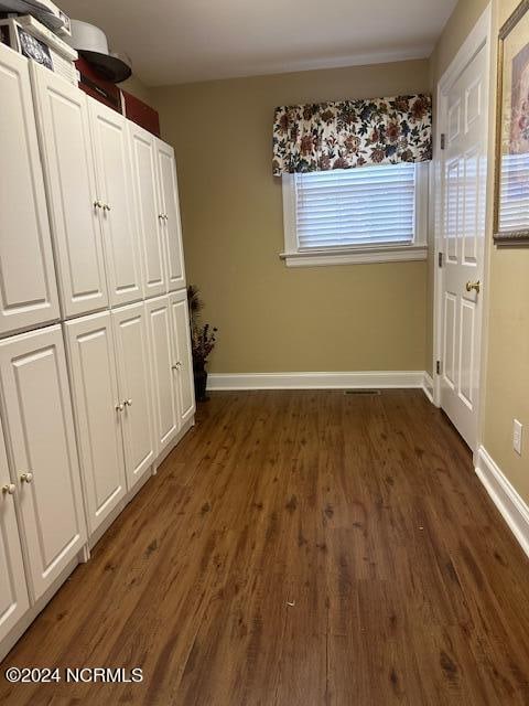 unfurnished bedroom featuring dark wood-type flooring and a closet