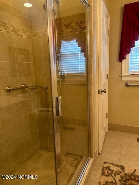 bathroom featuring tile patterned flooring and a shower with door