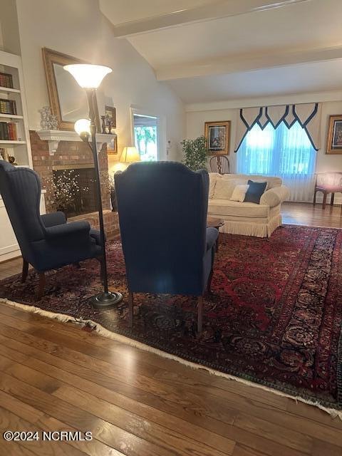 living room with vaulted ceiling with beams and hardwood / wood-style floors