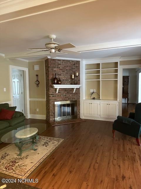 living room featuring ceiling fan, a fireplace, dark hardwood / wood-style floors, and ornamental molding