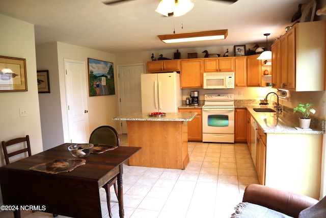 kitchen featuring ceiling fan, a center island, white appliances, sink, and hanging light fixtures