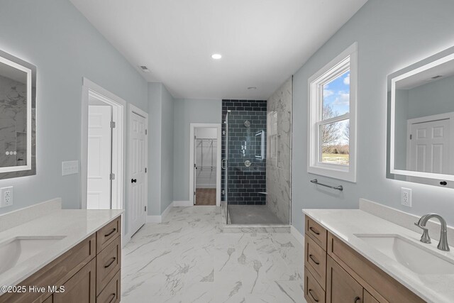 bathroom with tiled shower and vanity