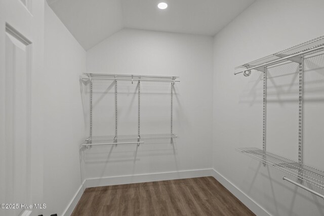 walk in closet featuring hardwood / wood-style flooring and lofted ceiling