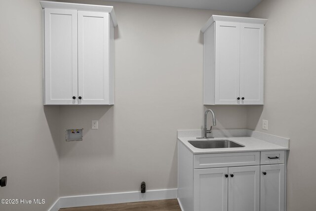 laundry area with washer hookup, cabinets, sink, and hardwood / wood-style floors