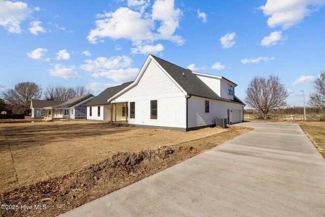 view of side of home featuring a garage and central air condition unit