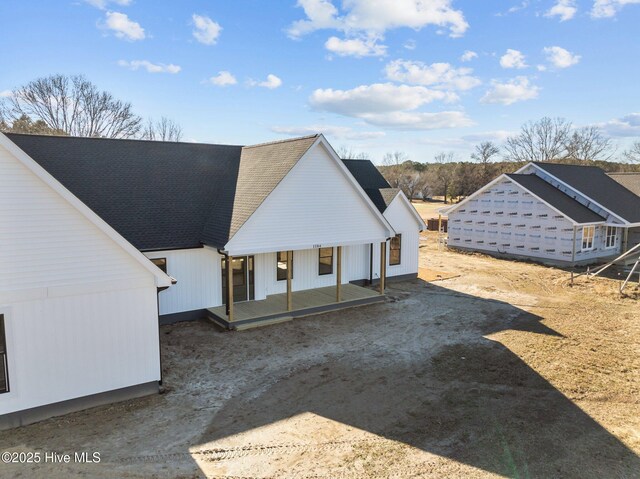 rear view of house featuring covered porch