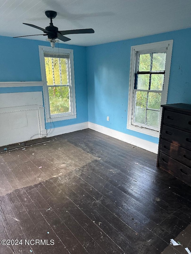 unfurnished living room featuring dark hardwood / wood-style floors and ceiling fan