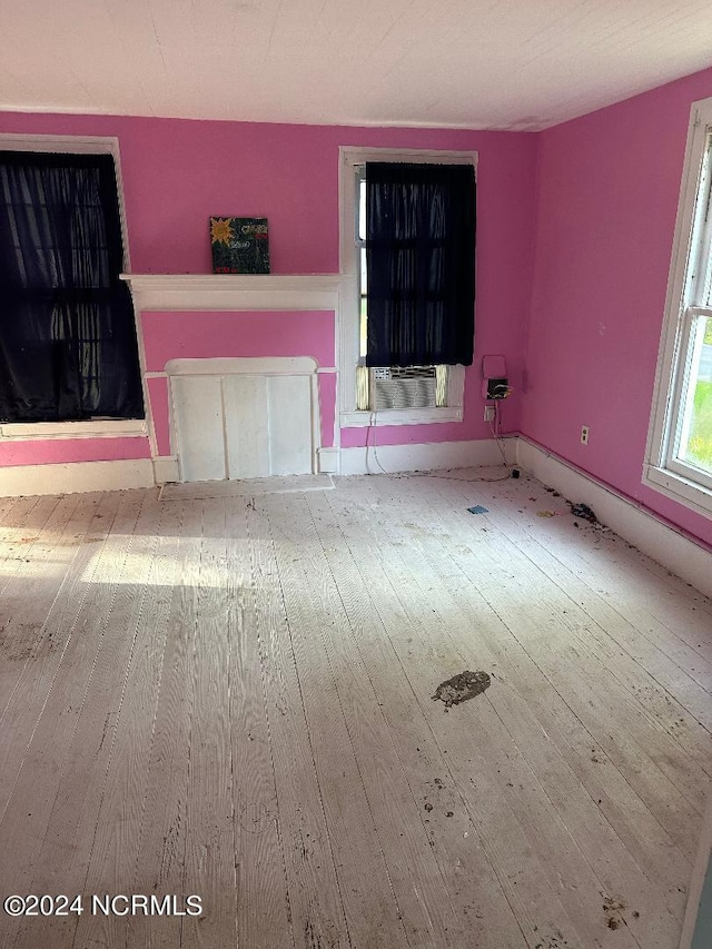 unfurnished living room featuring cooling unit, light hardwood / wood-style floors, and a fireplace