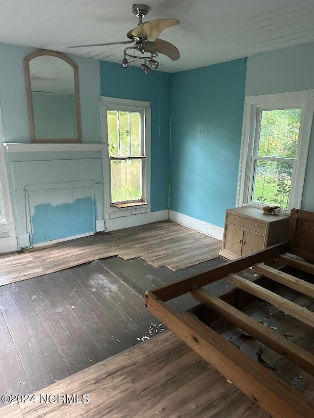 unfurnished living room with a healthy amount of sunlight, dark hardwood / wood-style flooring, and ceiling fan