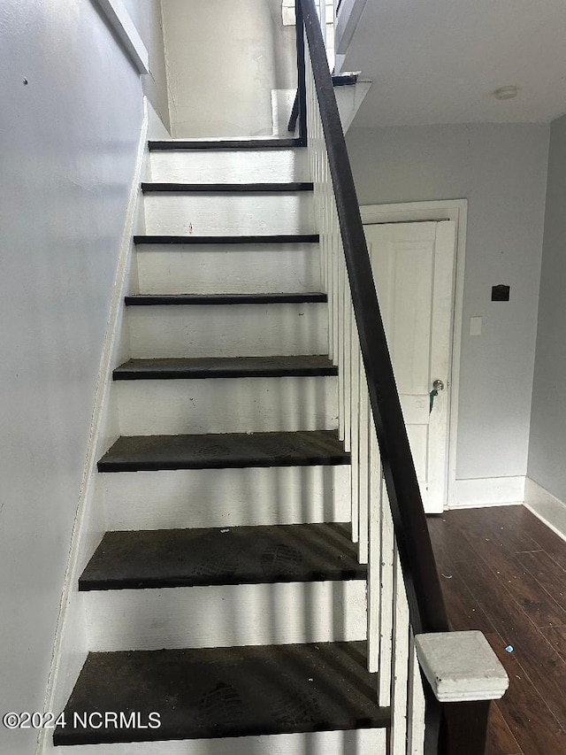 stairway with hardwood / wood-style flooring