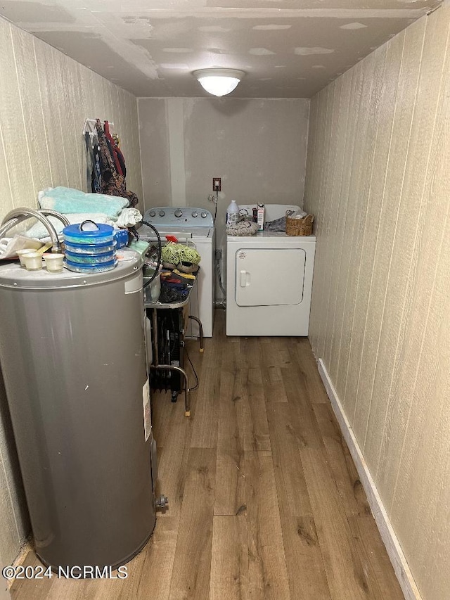 laundry room featuring washer and clothes dryer, electric water heater, and hardwood / wood-style floors