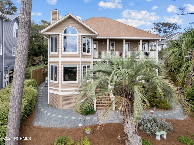 114 SW 21st St, Oak Island, NC 28465 - view of front of property with fence, a chimney, and a shingled roof