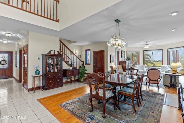 dining area with ceiling fan with notable chandelier and light tile patterned floors