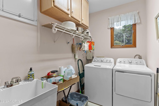 laundry area featuring washing machine and clothes dryer, sink, and cabinets