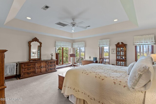 114 SW 21st St, Oak Island, NC 28465 - bedroom featuring carpet, a raised ceiling, a ceiling fan, and visible vents