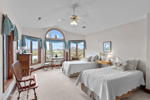 bedroom featuring light carpet, vaulted ceiling, multiple windows, and ceiling fan