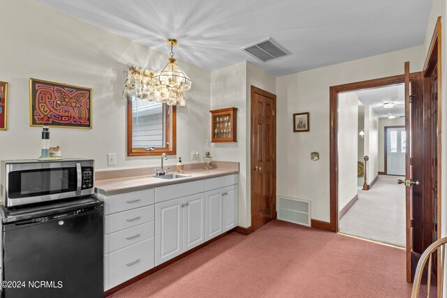 114 SW 21st St, Oak Island, NC 28465 - kitchen featuring stainless steel microwave, refrigerator, a sink, and visible vents