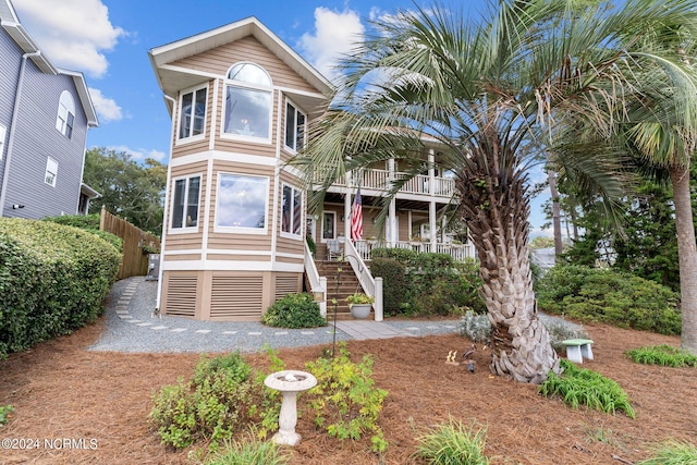 114 SW 21st St, Oak Island, NC 28465 - view of front of property featuring fence, stairway, covered porch, and a balcony