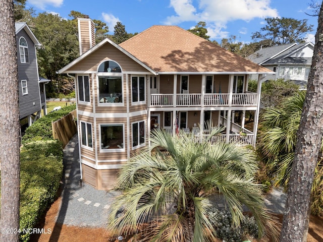 114 SW 21st St, Oak Island, NC 28465 - rear view of property with a chimney, a balcony, and a shingled roof