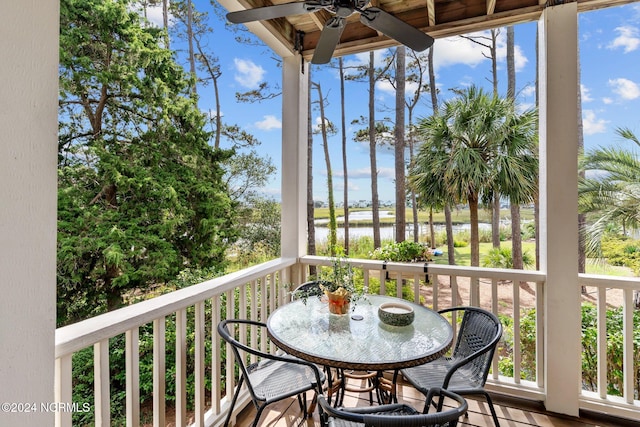 balcony with a water view and ceiling fan