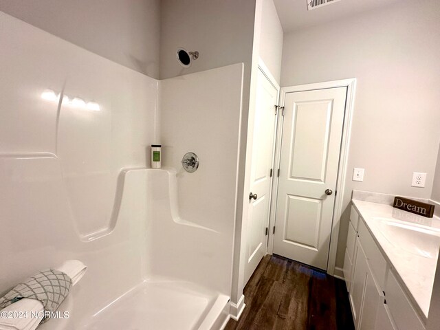 bathroom featuring vanity, hardwood / wood-style flooring, and walk in shower