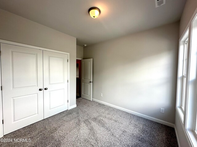 unfurnished bedroom with carpet flooring and a closet