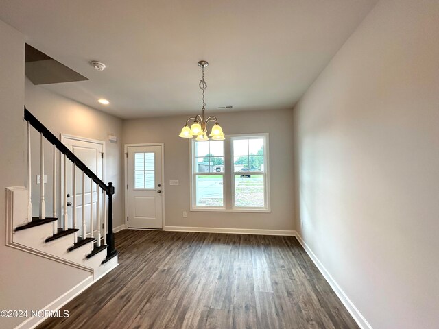 foyer entrance featuring dark wood-type flooring and an inviting chandelier