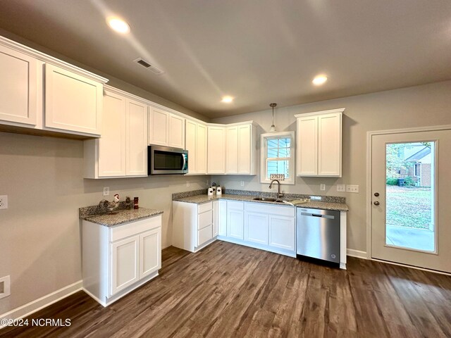 kitchen with pendant lighting, sink, white cabinetry, stainless steel appliances, and dark hardwood / wood-style floors