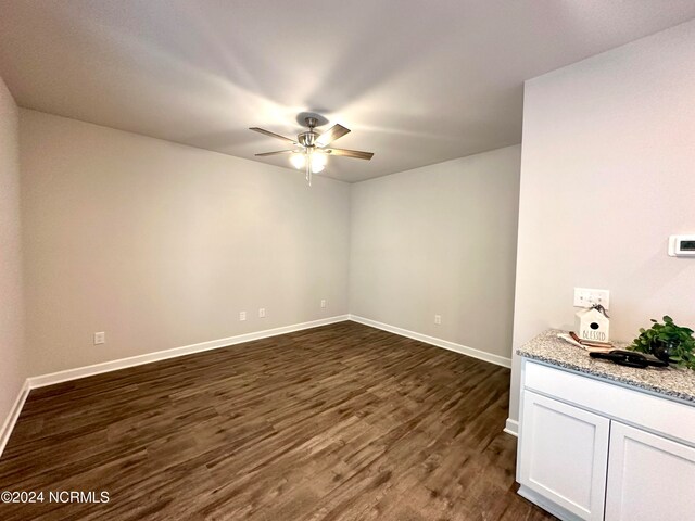 unfurnished room featuring dark hardwood / wood-style flooring and ceiling fan