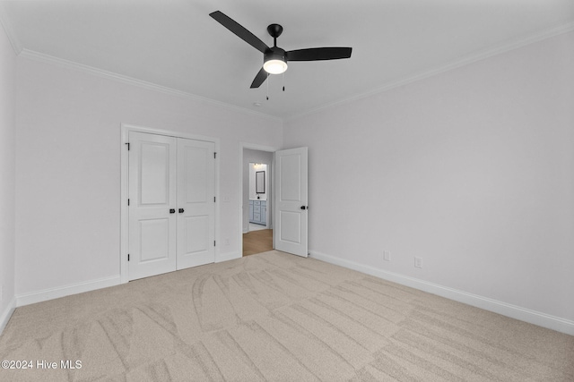 unfurnished bedroom featuring light carpet, a closet, ceiling fan, and ornamental molding