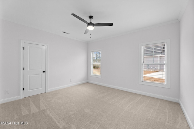 unfurnished room featuring ceiling fan, ornamental molding, and light carpet