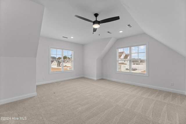 bonus room with ceiling fan, light colored carpet, a healthy amount of sunlight, and lofted ceiling