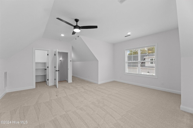 additional living space featuring ceiling fan, light colored carpet, and vaulted ceiling