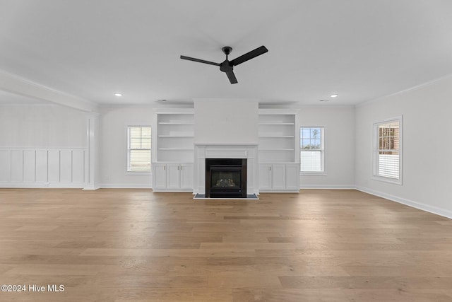 unfurnished living room with light hardwood / wood-style floors, plenty of natural light, crown molding, and ceiling fan