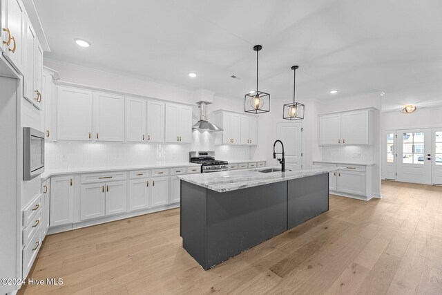 kitchen with a kitchen island with sink, sink, white cabinets, and stainless steel range with gas stovetop