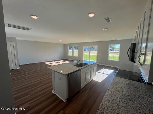 kitchen with dark wood-type flooring, sink, stainless steel dishwasher, an island with sink, and white cabinetry