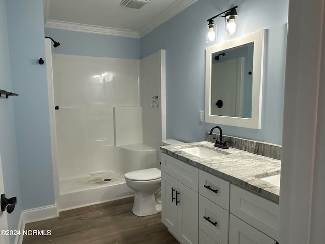 bathroom with wood-type flooring, walk in shower, crown molding, vanity, and toilet