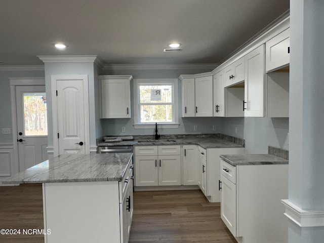 kitchen featuring white cabinets, a kitchen island, sink, and a wealth of natural light