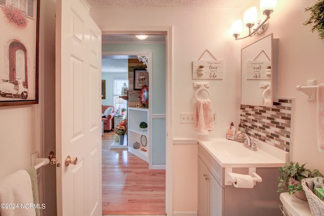 bathroom featuring vanity, hardwood / wood-style floors, a textured ceiling, and backsplash