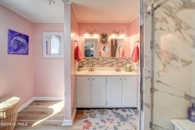 bathroom featuring a shower with door, backsplash, ornamental molding, hardwood / wood-style floors, and vanity