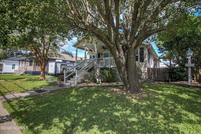 view of front facade featuring a front lawn, ceiling fan, and a porch