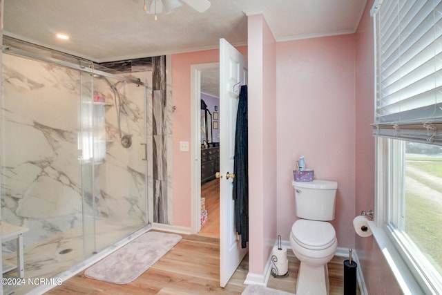 bathroom with toilet, hardwood / wood-style floors, crown molding, an enclosed shower, and ceiling fan