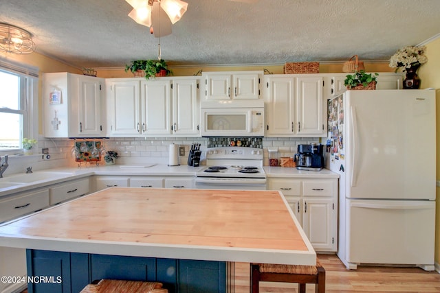 kitchen featuring white cabinets, a textured ceiling, light wood-type flooring, and white appliances