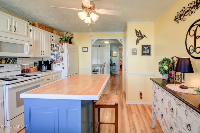 kitchen with white appliances, decorative backsplash, light hardwood / wood-style floors, white cabinets, and ornamental molding