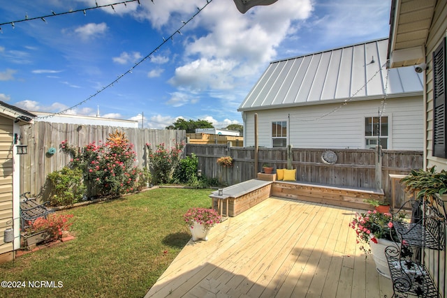 wooden terrace featuring a yard