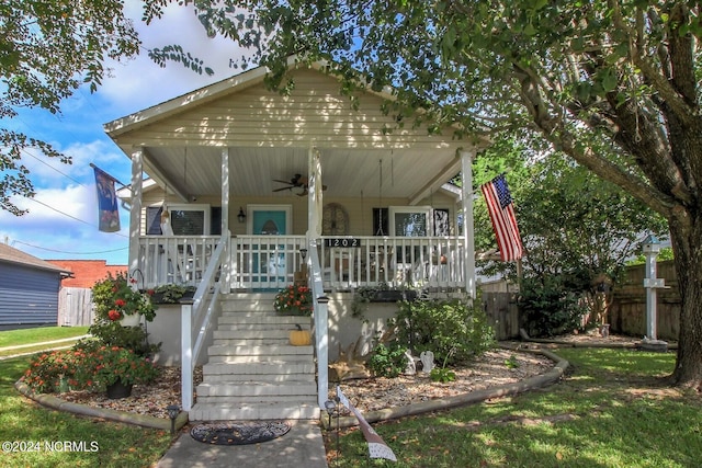 view of front facade with ceiling fan, a front yard, and a porch